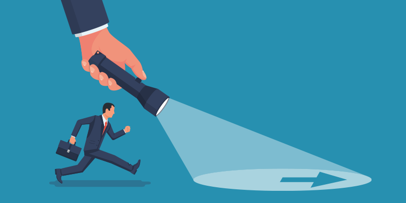 A large hand with a flashlight leads a businessman holding a briefcase toward an arrow, highlighting shadow IT detection for security.