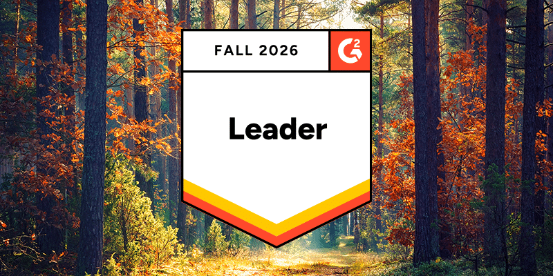 A “G2 Fall 2026 Leader” badge stands prominently in the center of a bright, sunlit forest with colorful autumn leaves and tall trees in the background, representing top recognition for BetterCloud.